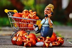 a woman talking on a cell phone next to a shopping cart filled with oranges