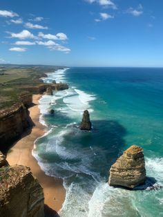 an aerial view of the beach and cliffs near the ocean with waves crashing on it