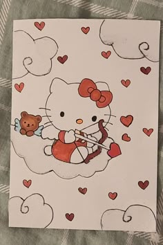 a hello kitty valentine card with hearts and a teddy bear on the front, sitting on a plaid blanket