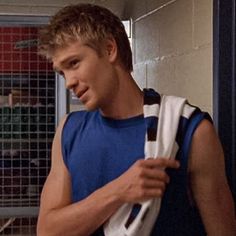 a young man in a blue shirt is holding a white and black bag