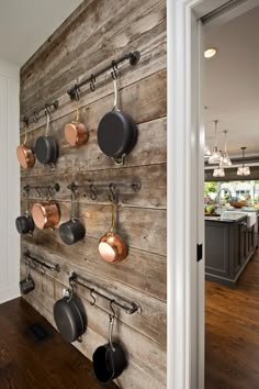 a wooden wall with pots and pans mounted to it's sides in a kitchen