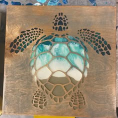 a wooden plaque with a sea turtle painted on it