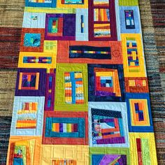 a multicolored patchwork quilt with squares and rectangles on the edges