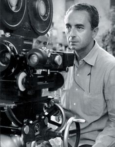 a man standing next to a movie camera