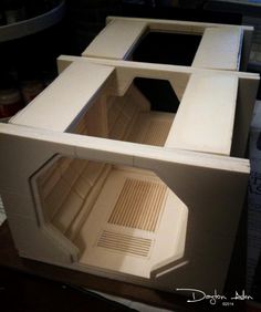 the inside of a model made out of cardboard with no door and two shelves on each side