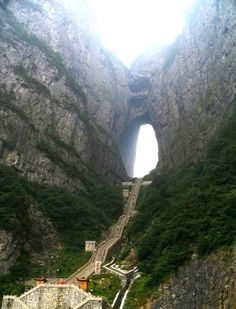 an aerial view of a mountain with a tunnel in the middle and stairs leading up to it