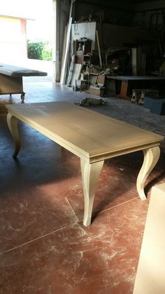 a wooden table sitting on top of a hard wood floor next to a garage door