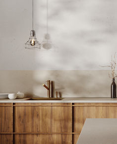 a kitchen with wooden cabinets and white counter tops, an overhead light hangs over the sink