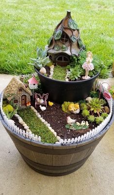 a potted planter filled with lots of plants and small fairy figurines