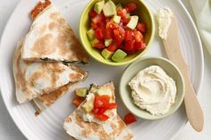 a white plate topped with quesadillas and dip