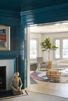 a living room with blue painted walls and a fire place in the corner, surrounded by furniture