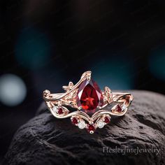 a red stone ring sitting on top of a rock