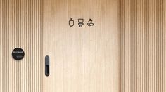 the door is made of wood and has black knobs on each side, which are marked with different symbols