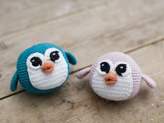 two small crocheted birds sitting on top of a wooden floor next to each other