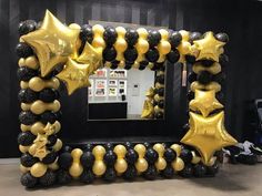 a black and gold balloon arch with stars