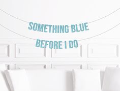 a white couch sitting next to a wall with something blue before i do written on it