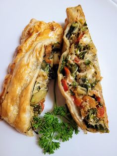 a white plate topped with two pieces of pie next to a green leafy garnish