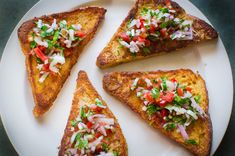 four pieces of toast with toppings on a white plate