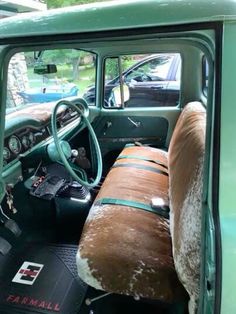 the interior of an old green truck with sheepskin on it's seat covers