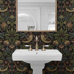 a white sink sitting under a mirror next to a wall mounted faucet in a bathroom