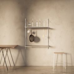 an empty room with two chairs and a shelf holding utensils on the wall