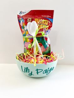 a bowl filled with candy and confetti on top of a white countertop