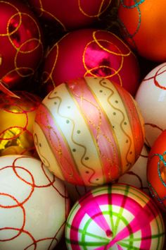 many different colored christmas ornaments in a pile