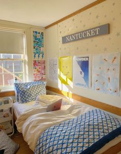 a bed room with a neatly made bed and pictures on the wall