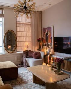 a living room filled with furniture and a chandelier hanging over it's windows