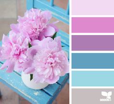 pink flowers are in a white vase on a blue bench with color swatches below