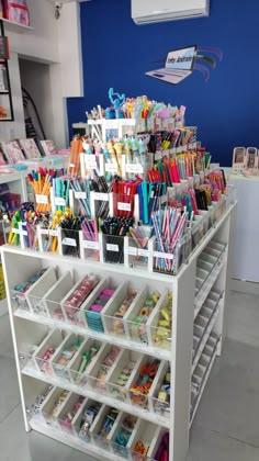 a white shelf filled with lots of different colored pens and pencils on top of it