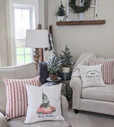 the living room is decorated for christmas with red and white striped pillows, wreaths on the window sill