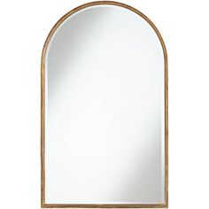 an arch shaped mirror on a white wall