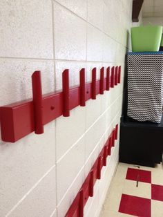 a red and white tiled hallway with two bins on the wall next to each other