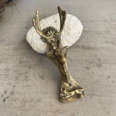 a metal object sitting on top of a cement floor next to a white rock and basket