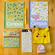 the contents of a pokemon themed school bag laid out on a wooden table with pens and stickers