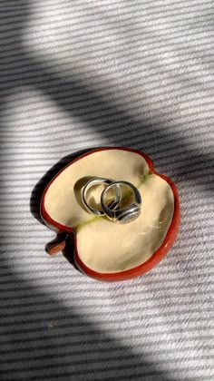 two wedding rings are placed in an apple