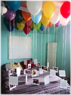 balloons are floating in the air over a table with pictures and photos on it's sides