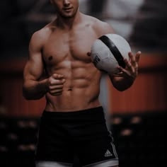 a shirtless man holding a soccer ball