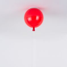 a red balloon is suspended from the ceiling