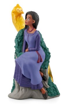 a figurine of a woman sitting on a chair with a fish in her hand