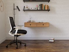 an office chair sitting in front of a desk with bookshelves and shelves above it