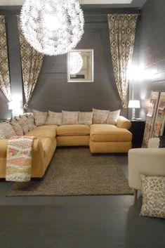 a living room filled with furniture and a chandelier hanging from the ceiling above