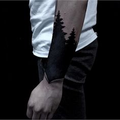 a man with a forest tattoo on his arm