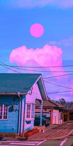 a blue house with a pink sky and clouds in the backgroung area