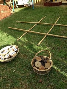 a basket full of logs sitting on top of a grass covered field next to a picnic table