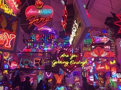 many neon signs are hanging from the ceiling