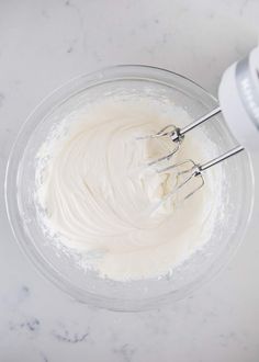 two whisk attachments in a bowl filled with whipped cream