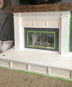 a white fireplace with green trim around the mantel and tv on top of it