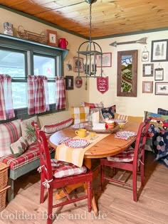 a table and chairs in a room with pictures on the wall